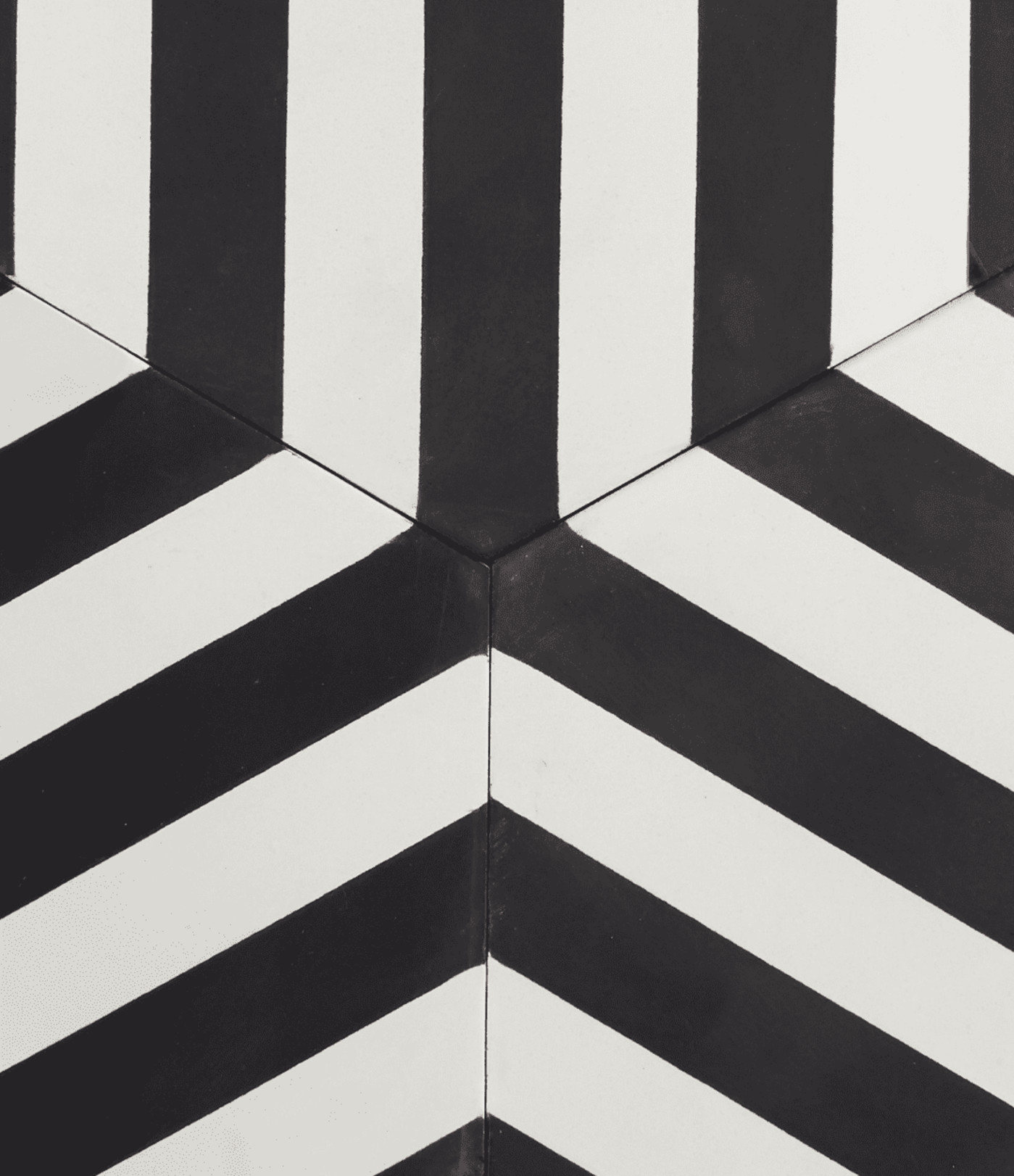 the meeting point between three black and white striped hexagon tiles.