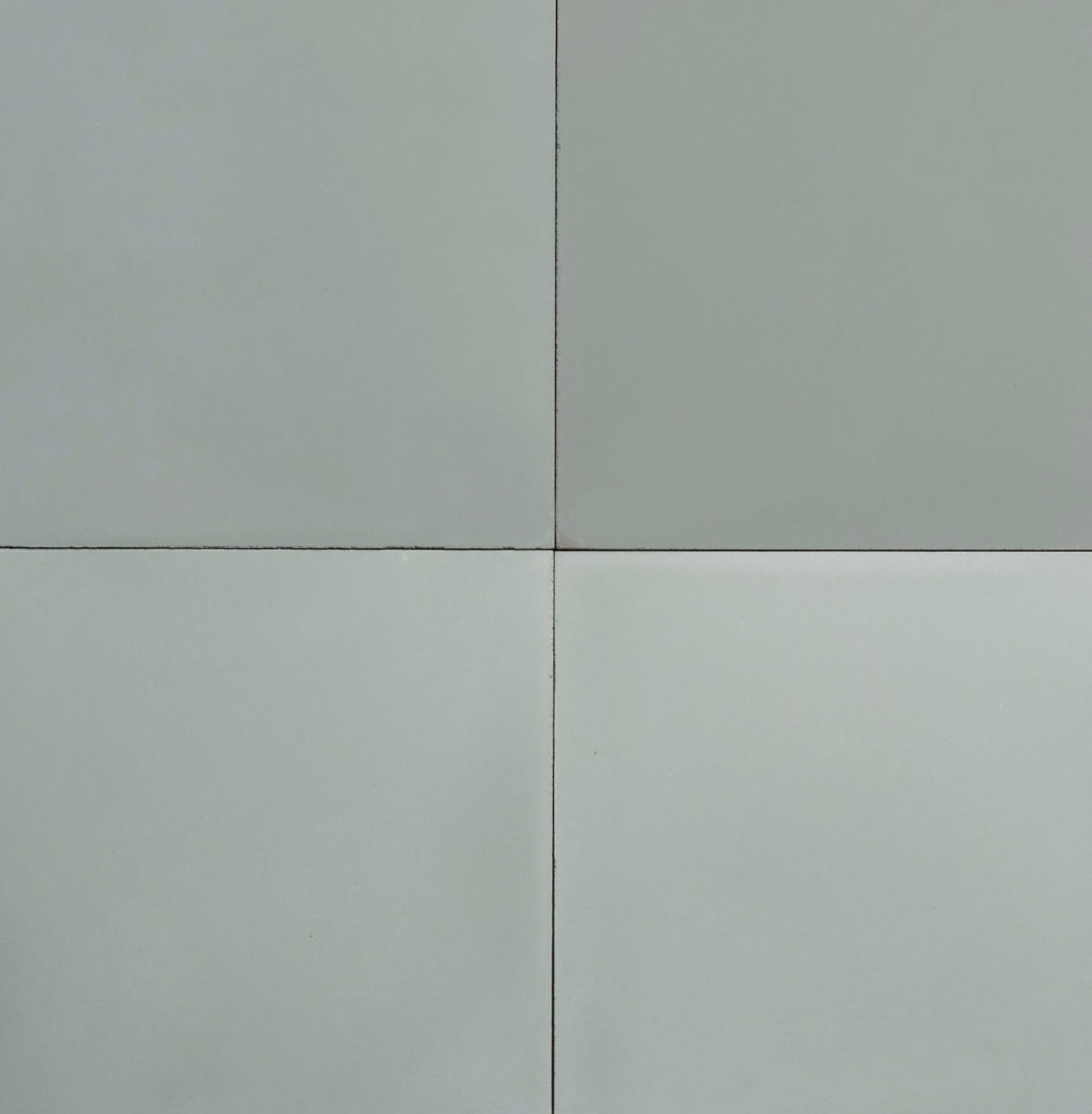 a set of four square tiles in a light green color.