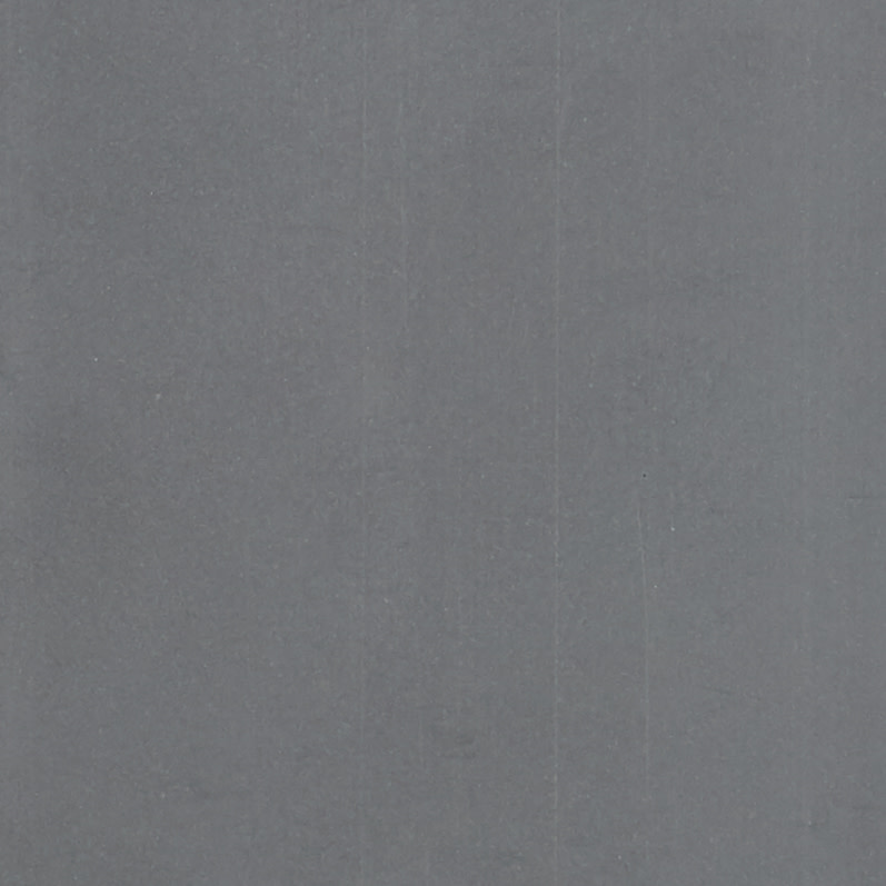 Plain gray surface (fabric or paper) with faint vertical creases and light speckling; filling the frame, static; evenly lit close-up, neutral background.
