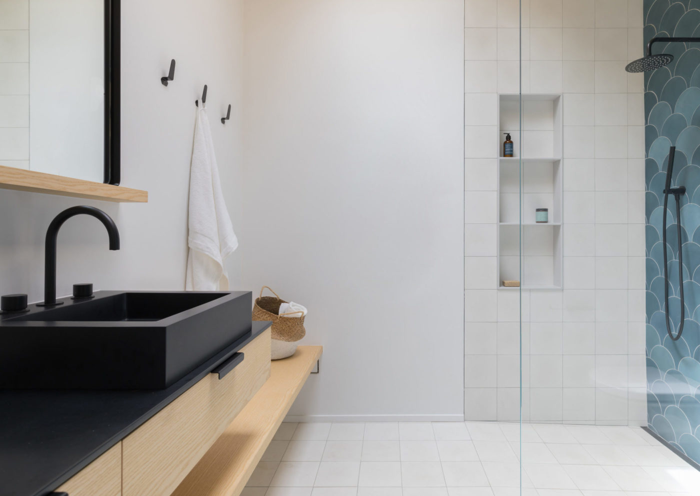 a modern bathroom with a blue tiled shower wall.