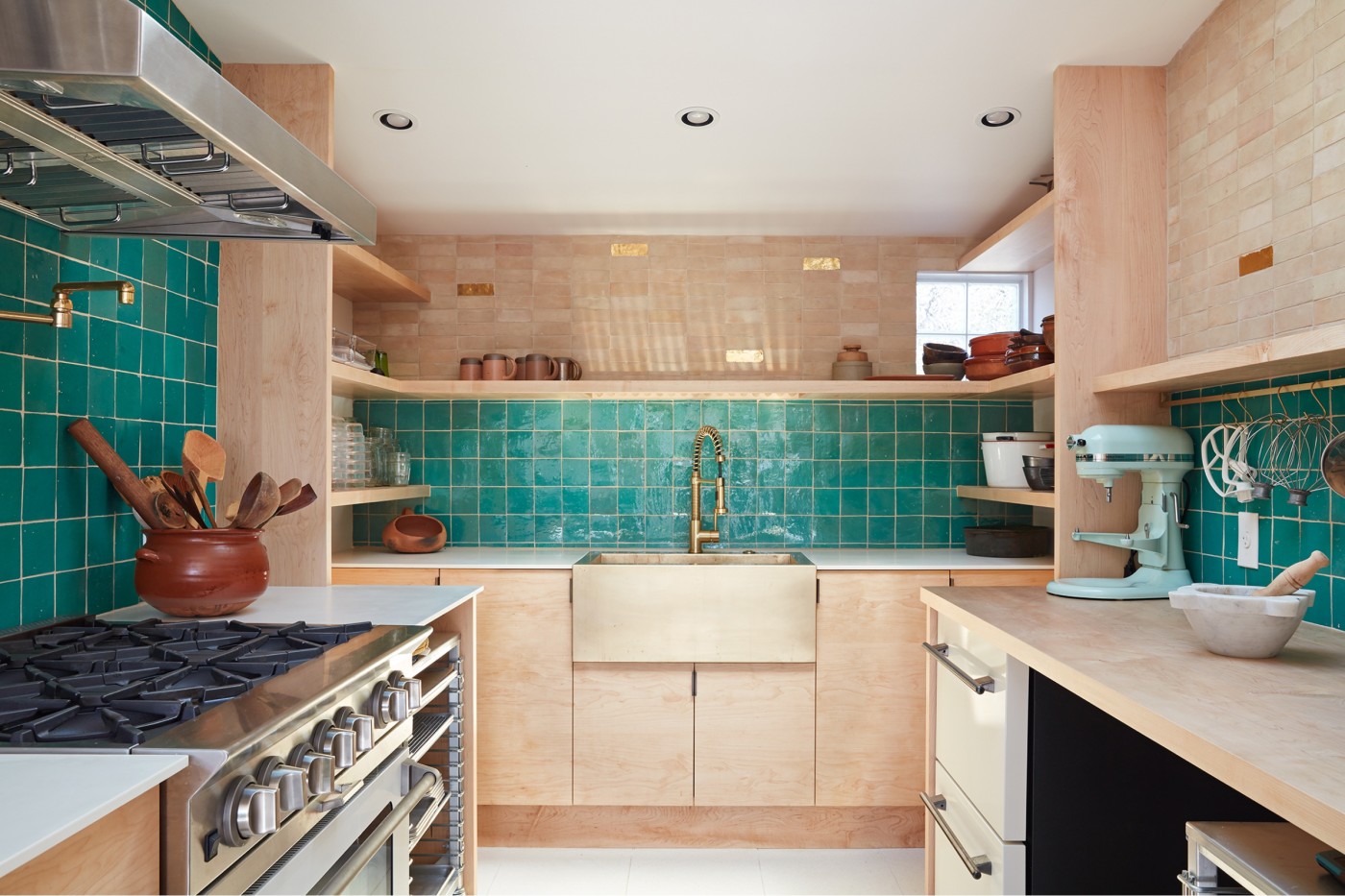 a kitchen with green tiled walls.