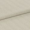 Cream herringbone-woven fabric folded diagonally, showing raised ribbed chevron pattern; laid flat under soft, even lighting for a close-up textile detail.
