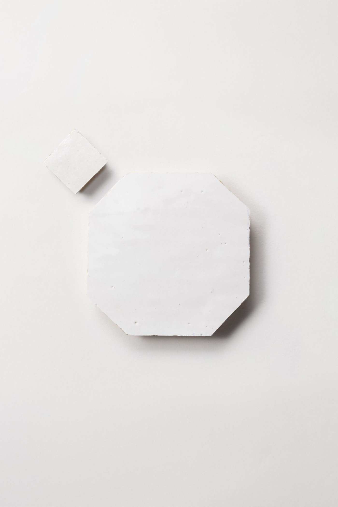 a white plate with a small piece of marble on it.