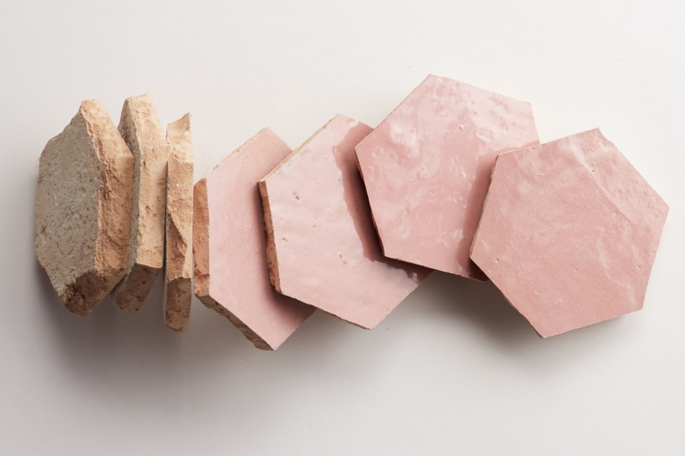 a set of pink hexagonal tiles on a white surface.