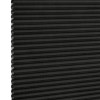 Black cellular (honeycomb) pleated blind, lowered and closed with left-edge cells exposed, blocking light; close-up studio product shot on neutral white background with even lighting.