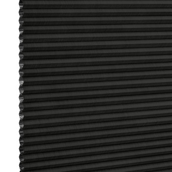 Black cellular (honeycomb) pleated blind, lowered and closed with left-edge cells exposed, blocking light; close-up studio product shot on neutral white background with even lighting.