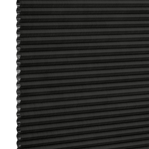 Black cellular (honeycomb) pleated blind, lowered and closed with left-edge cells exposed, blocking light; close-up studio product shot on neutral white background with even lighting.