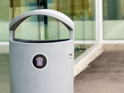 grey waste bin with canopy lid outdoors at high school