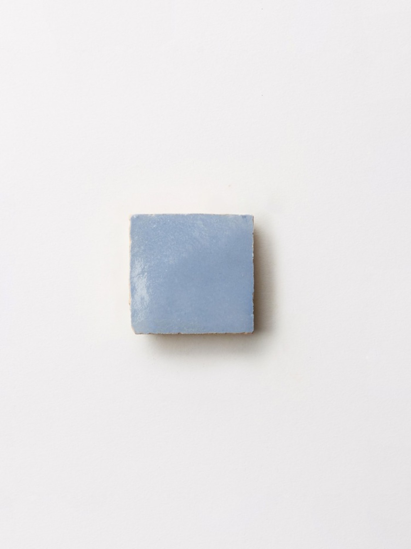 a blue square tile on a white surface.