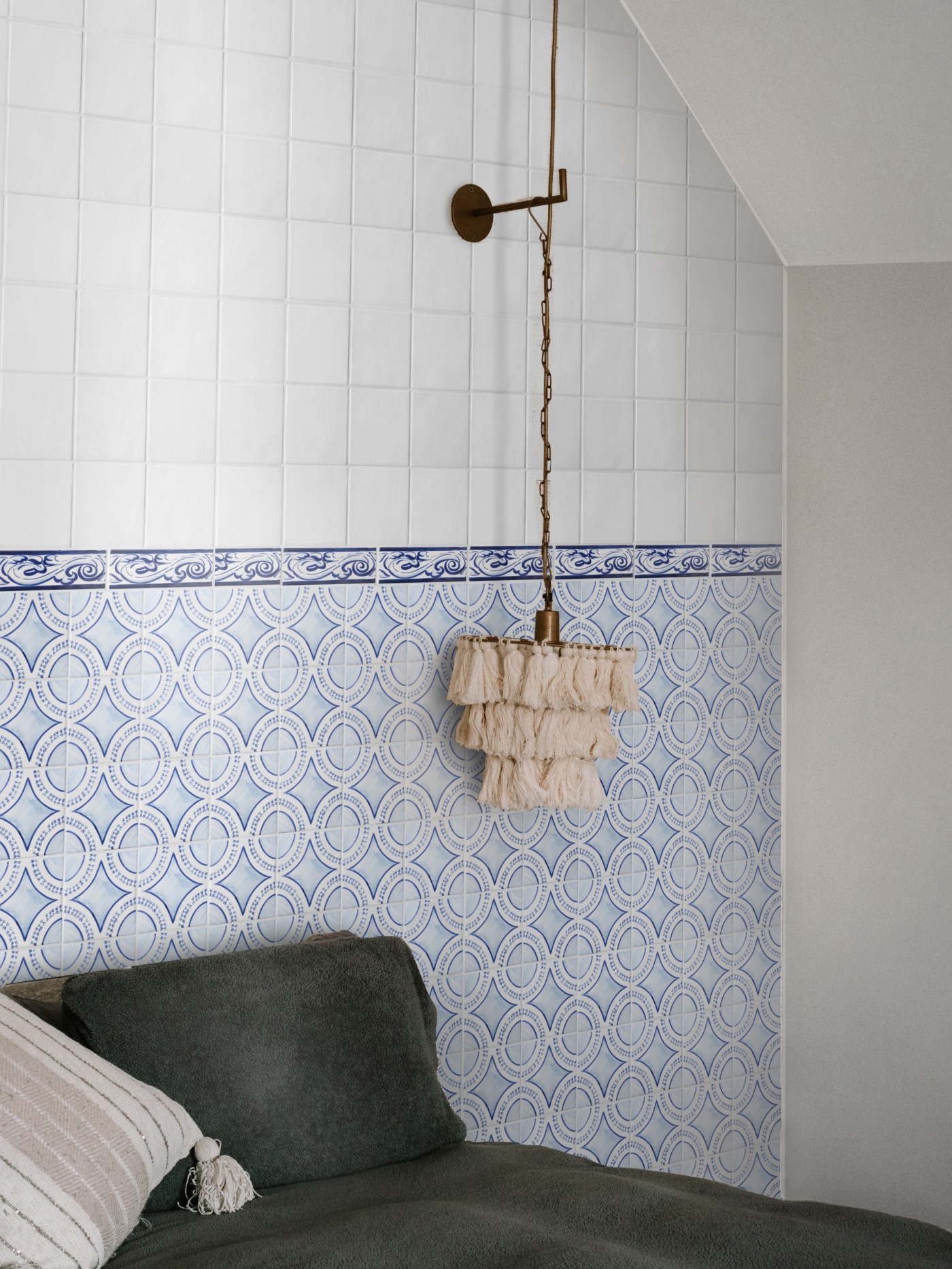 a bed in a room with blue and white tiled walls.