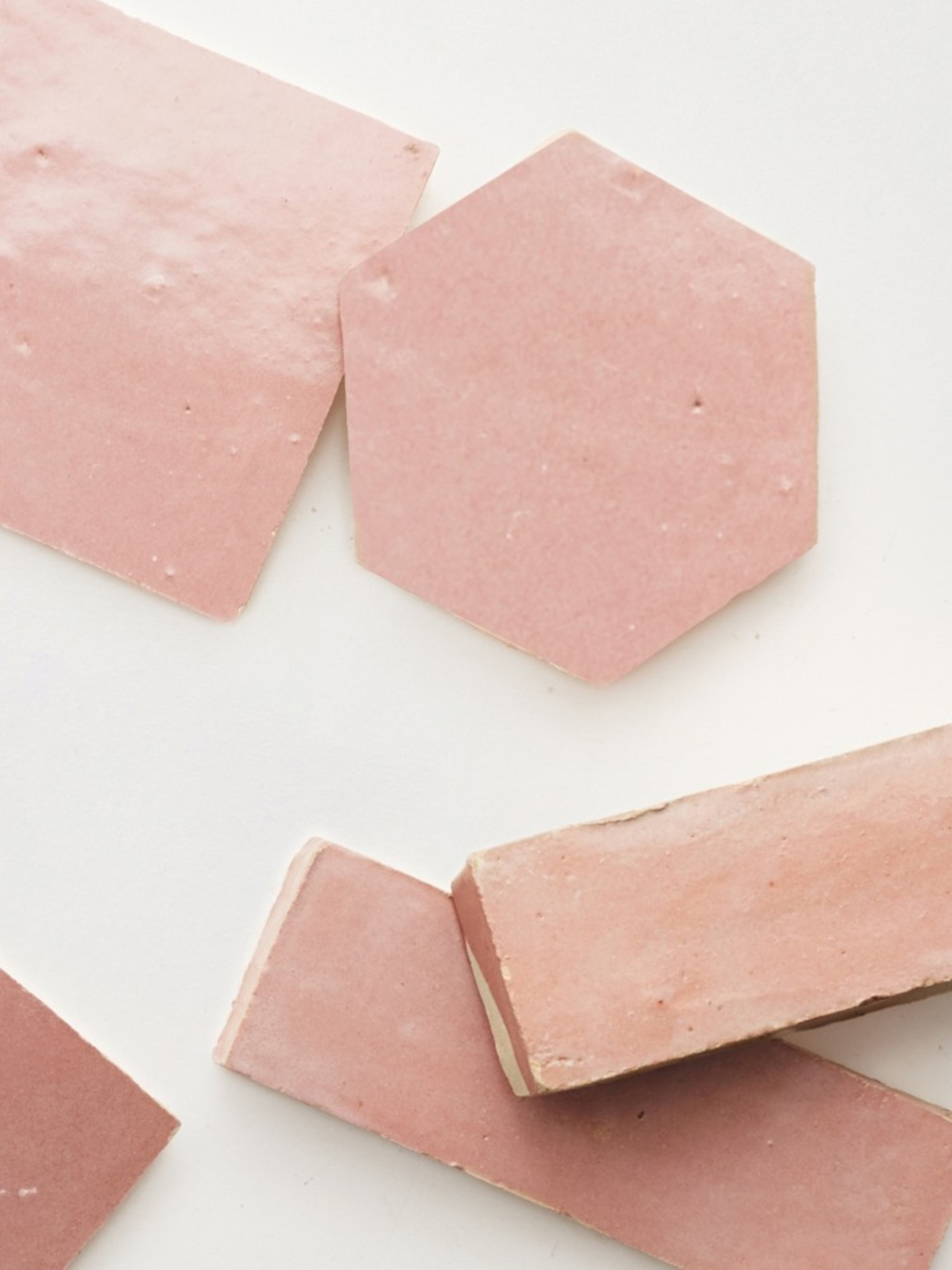 a group of pink tiles laid out on a white surface.