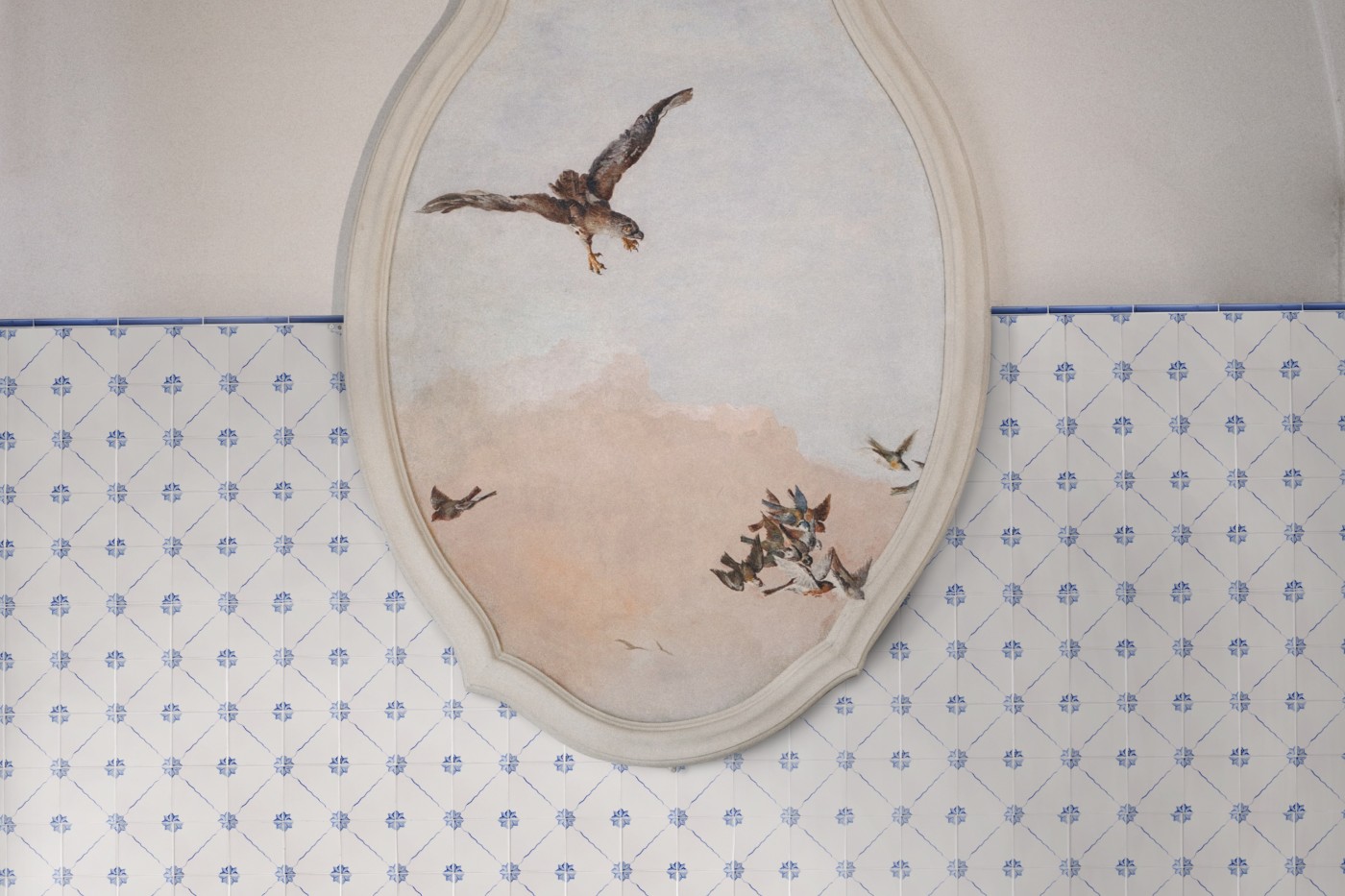 a painting of an eagle on a blue and white tiled wall.