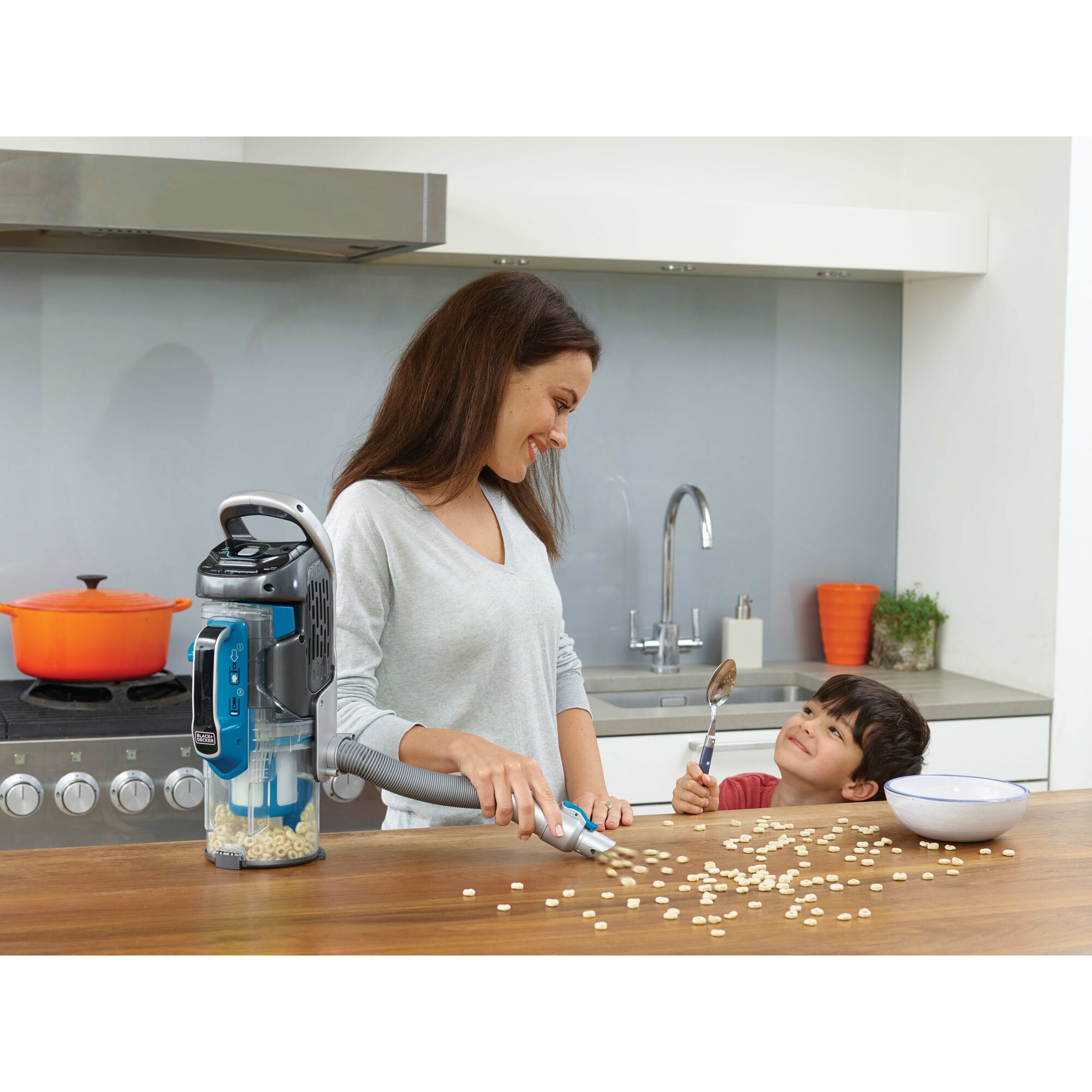 POWER SERIES PRO cordless 2 in 1 vacuum being used by a person to clean food spillage on kitchen counter.