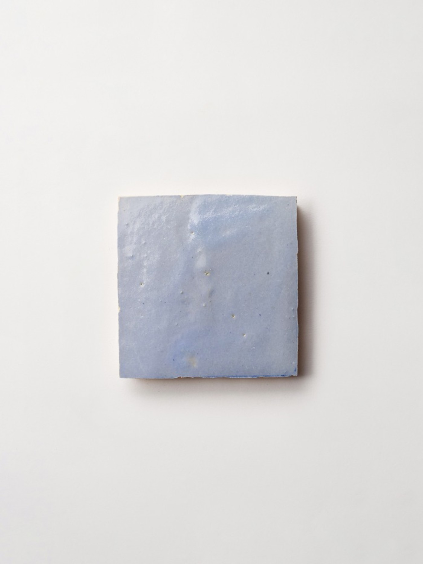 a grey square tile on a white surface.