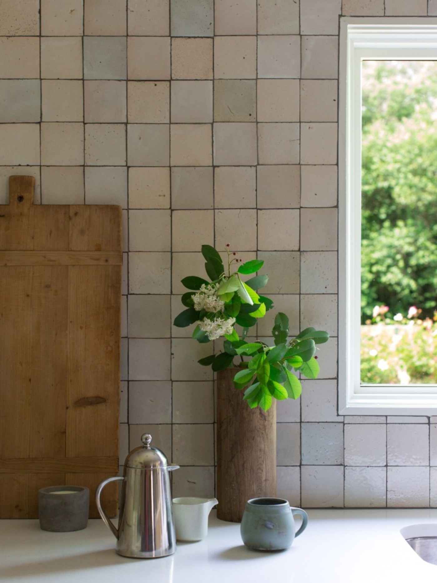 a kitchen with a window and a potted plant.