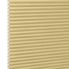 Honeycomb cellular blind, beige with visible hexagonal cells at left edge and narrow horizontal pleats â€” fully lowered and closed, filtering soft light in a close-up, neutral setting.