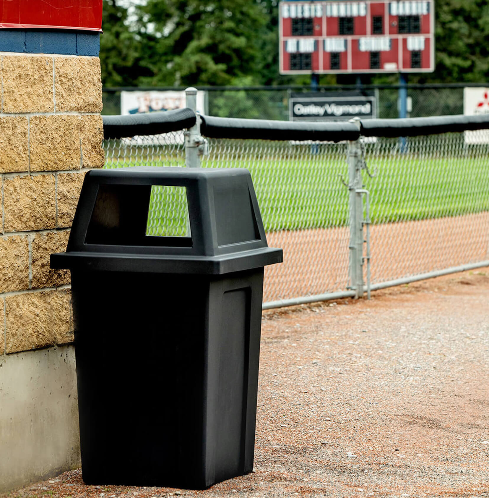 large outdoor trash bin made from durable black LDPE plastic outside at a baseball field