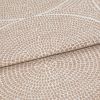 Beige and cream woven fabric with dense pebble-like dot pattern arranged in radiating rings; folded once across the frame, showing raised texture and subtle sheen in neutral studio lighting.