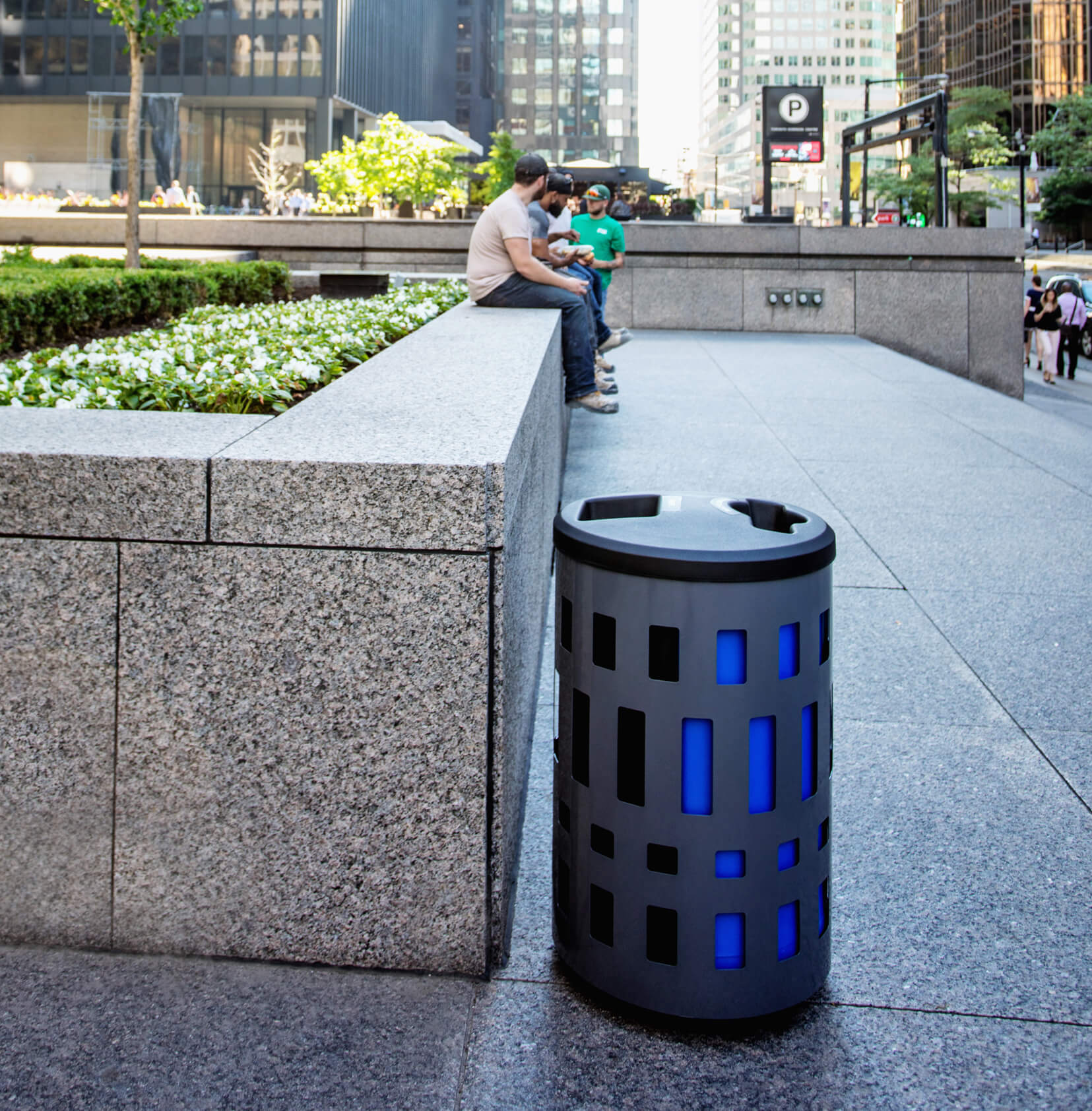 double waste and recycling bin with grey steel body and blue and black liners with plastic lid outdoors at a downtown office building