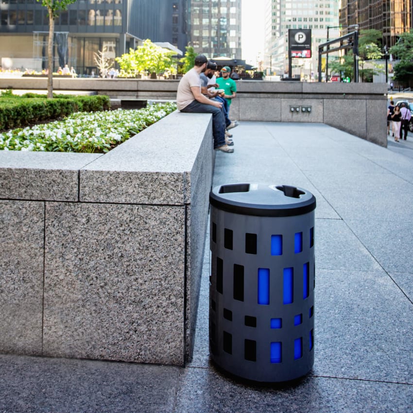 double waste and recycling bin with grey steel body and blue and black liners with plastic lid outdoors at a downtown office building