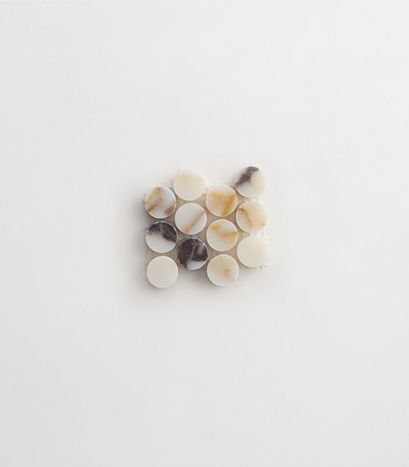 brown, black and white penny round tiles on a white surface.