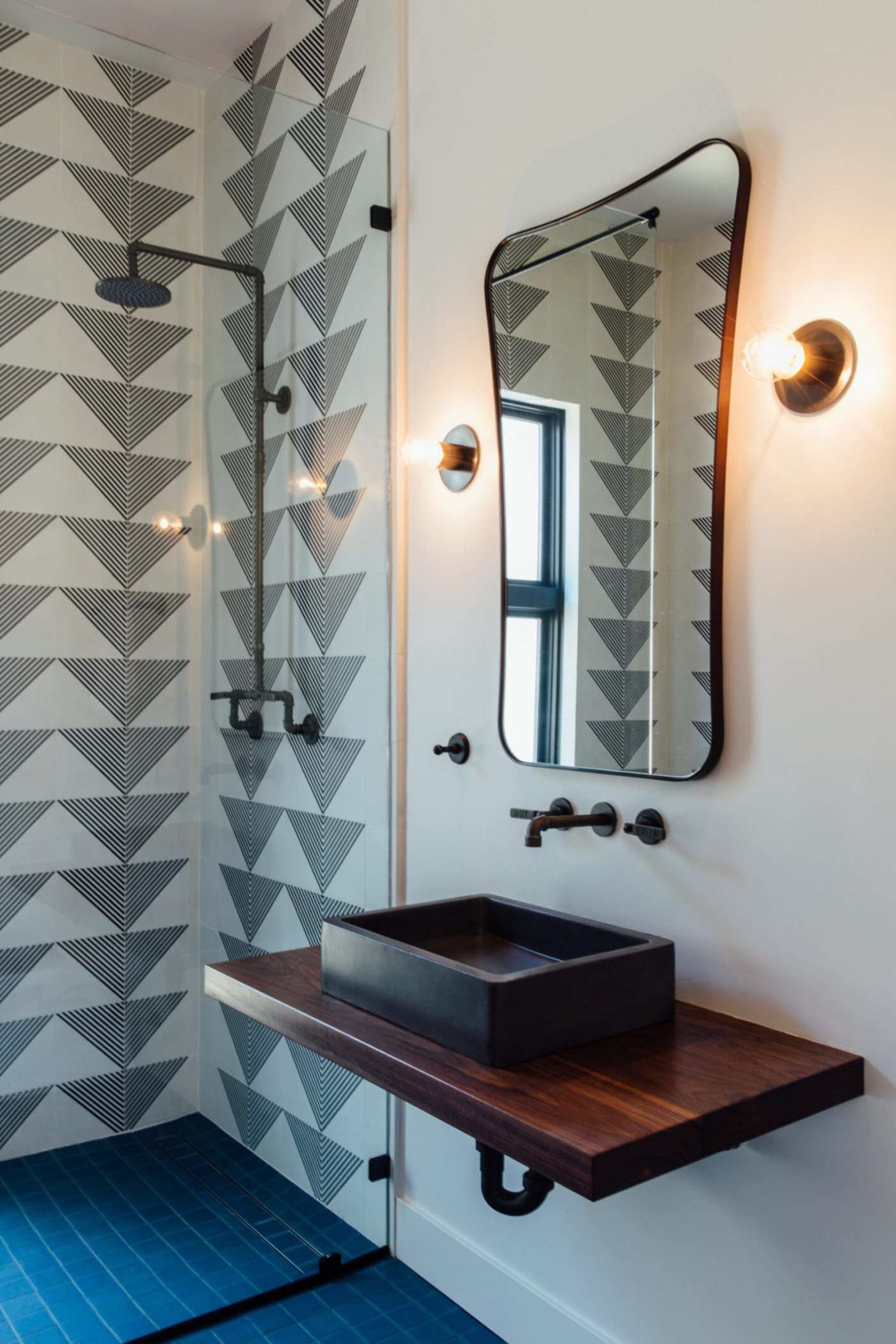 a bathroom with a blue tiled floor and a mirror.