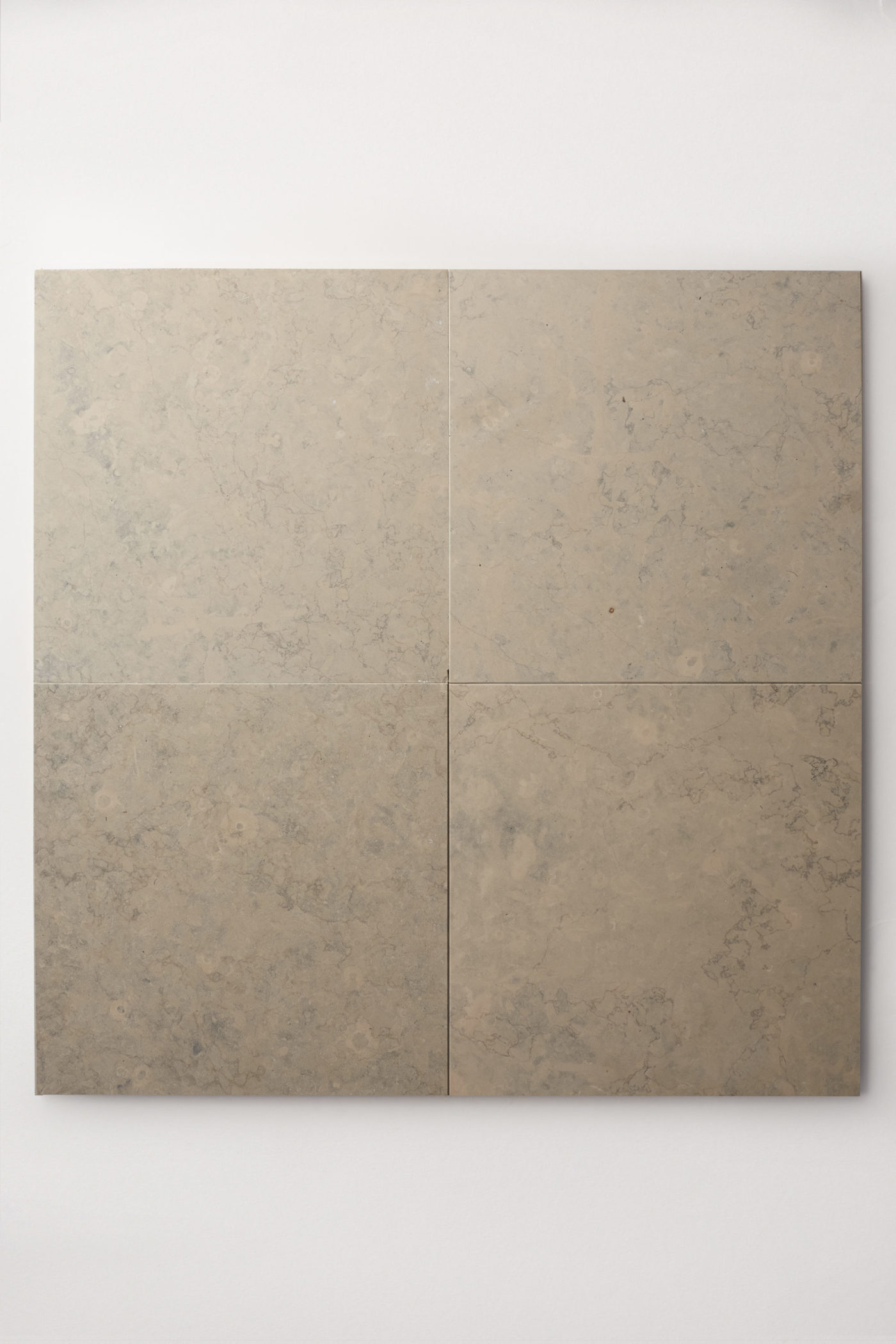 four square grey limestone tiles on a white surface.