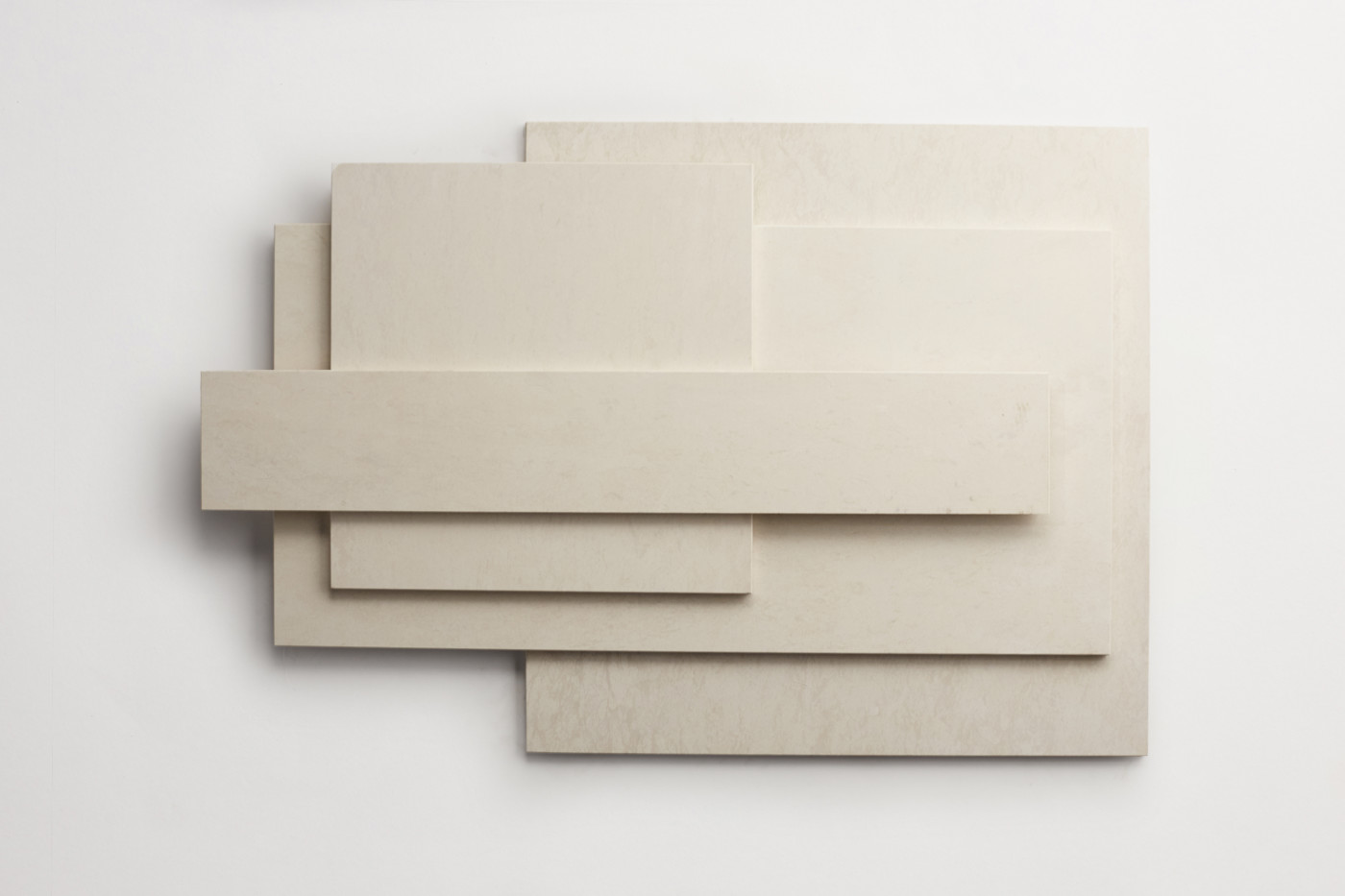 different-sized off-white tiles arranged artfully against a white background.