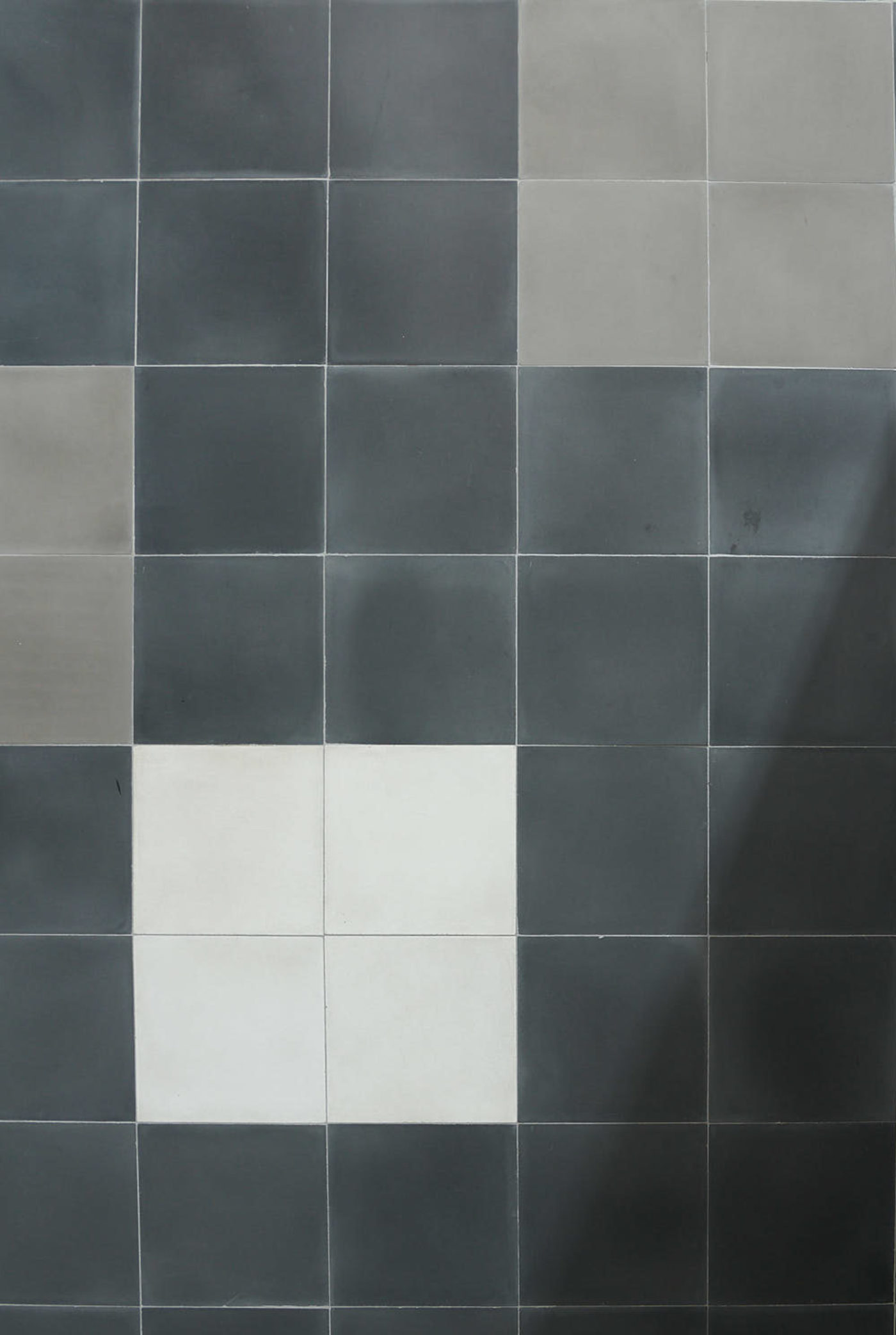 a bathroom with a blue, grey and white tiled wall.