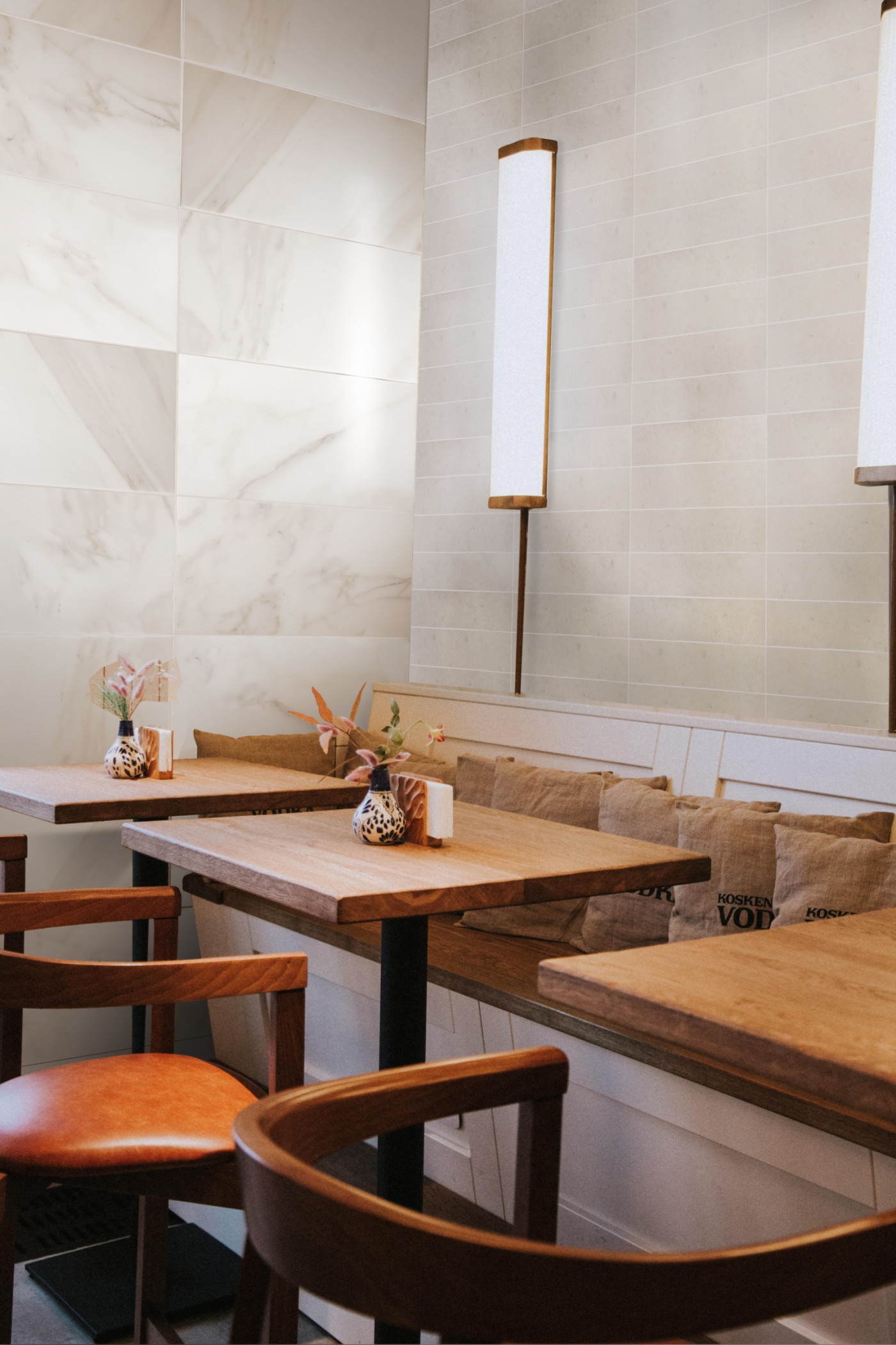 a restaurant with wooden tables and light limestone tiled walls.