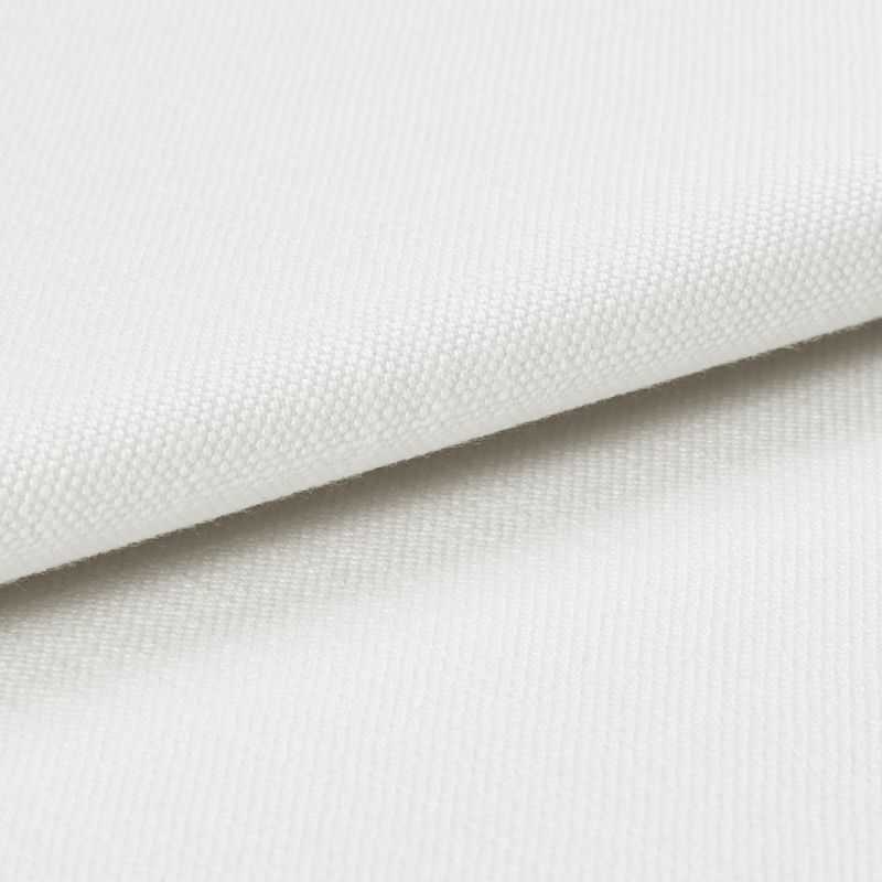 White canvas-like fabric folded diagonally, displaying a fine woven texture and overlapping edge; close-up studio view with soft, even lighting and neutral background emphasizing the weave detail.