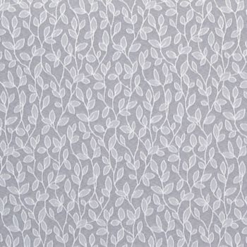 Sheer, white-embroidered curtain hung flat, its repeating vine-and-leaf motif running vertically; filtering soft light against a muted gray background, suggesting an interior window or decorative wall covering.