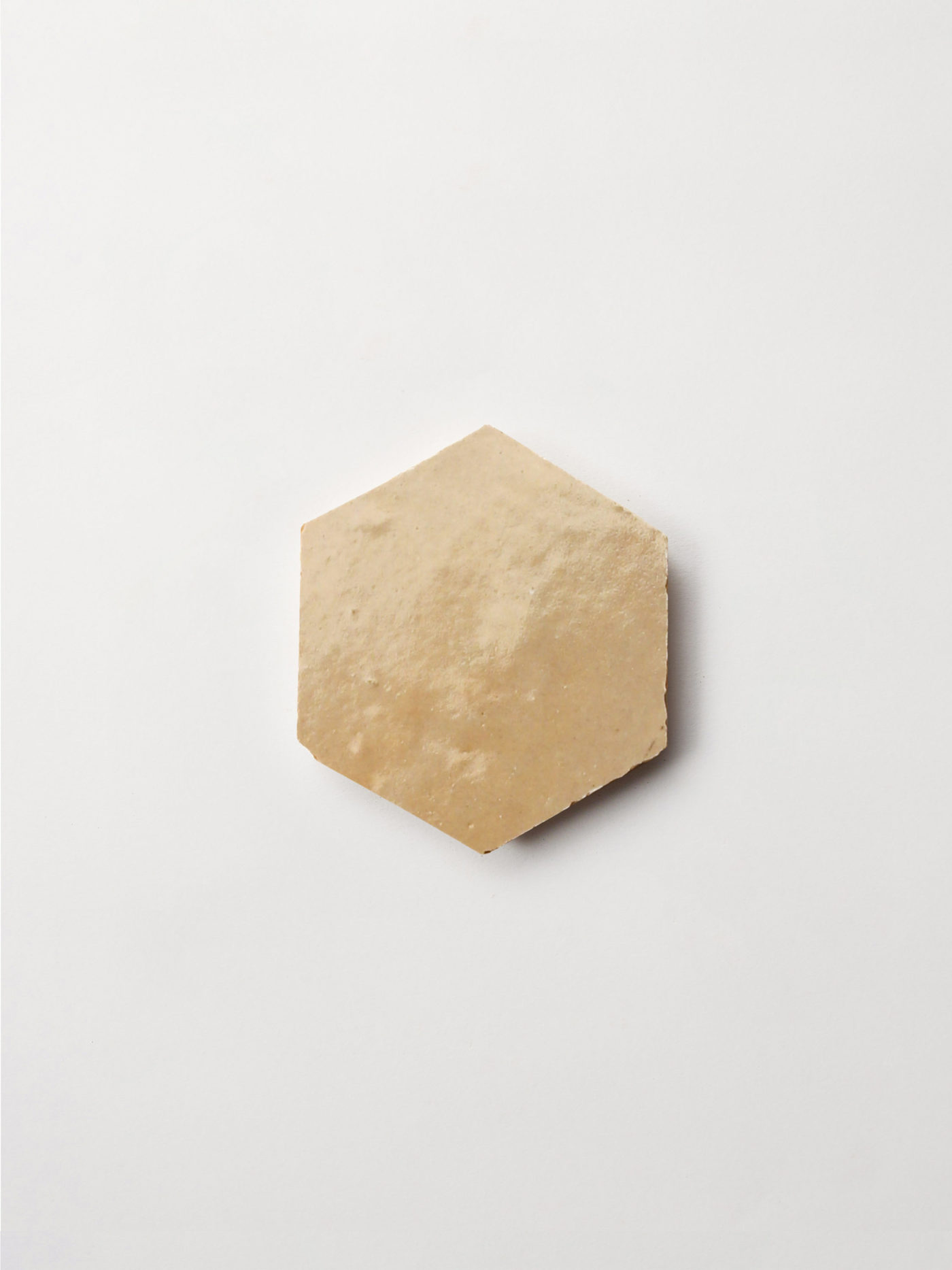 a light brown hexagonal tile on a white surface.