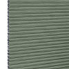 Cellular honeycomb blind â€” sage-green pleated fabric fully lowered with exposed hexagonal cells along the left edge; blocking and softly filtering light in a neutral interior.