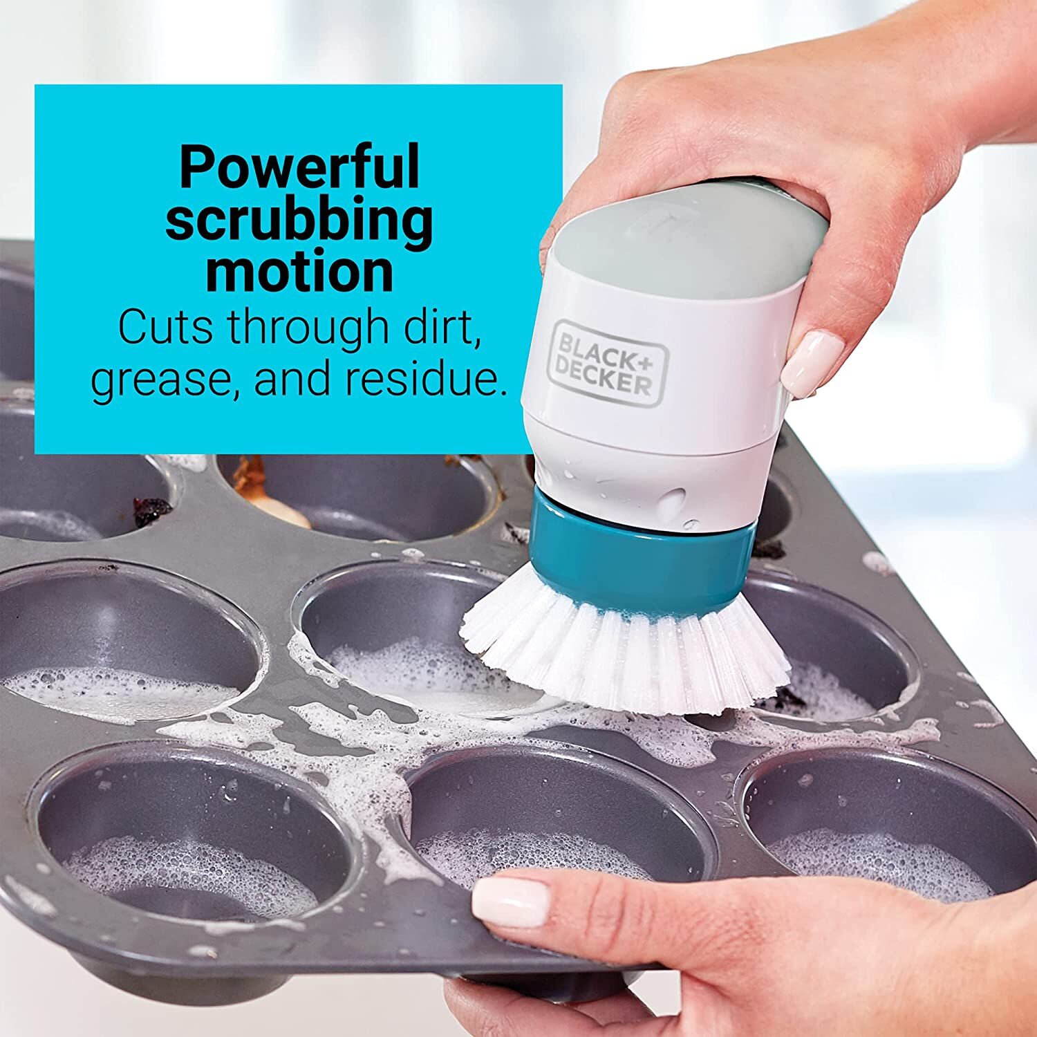 Grimebuster powered scrubber being used by a person to clean a muffin tray.