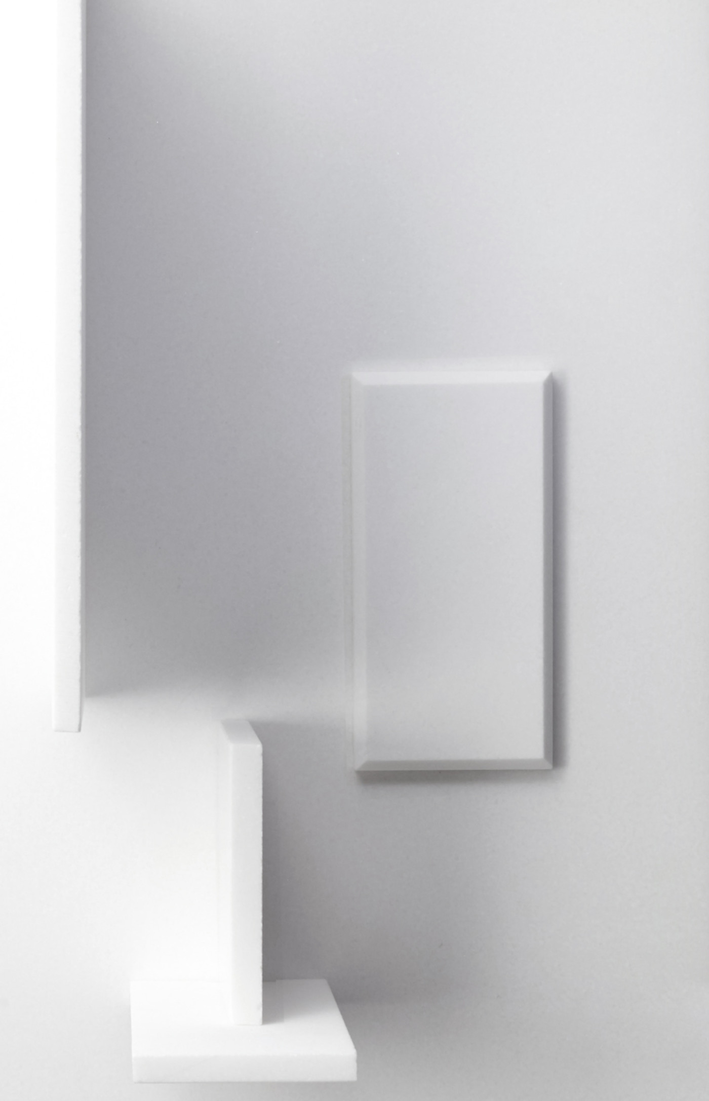 a white wall with a white box and a white shelf.