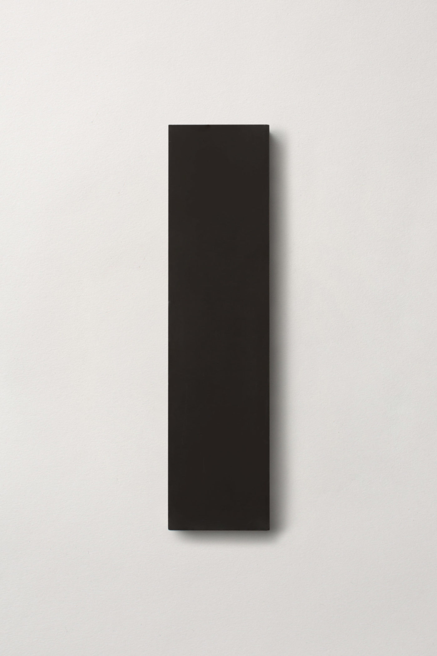 a black rectangle tile on a white surface.