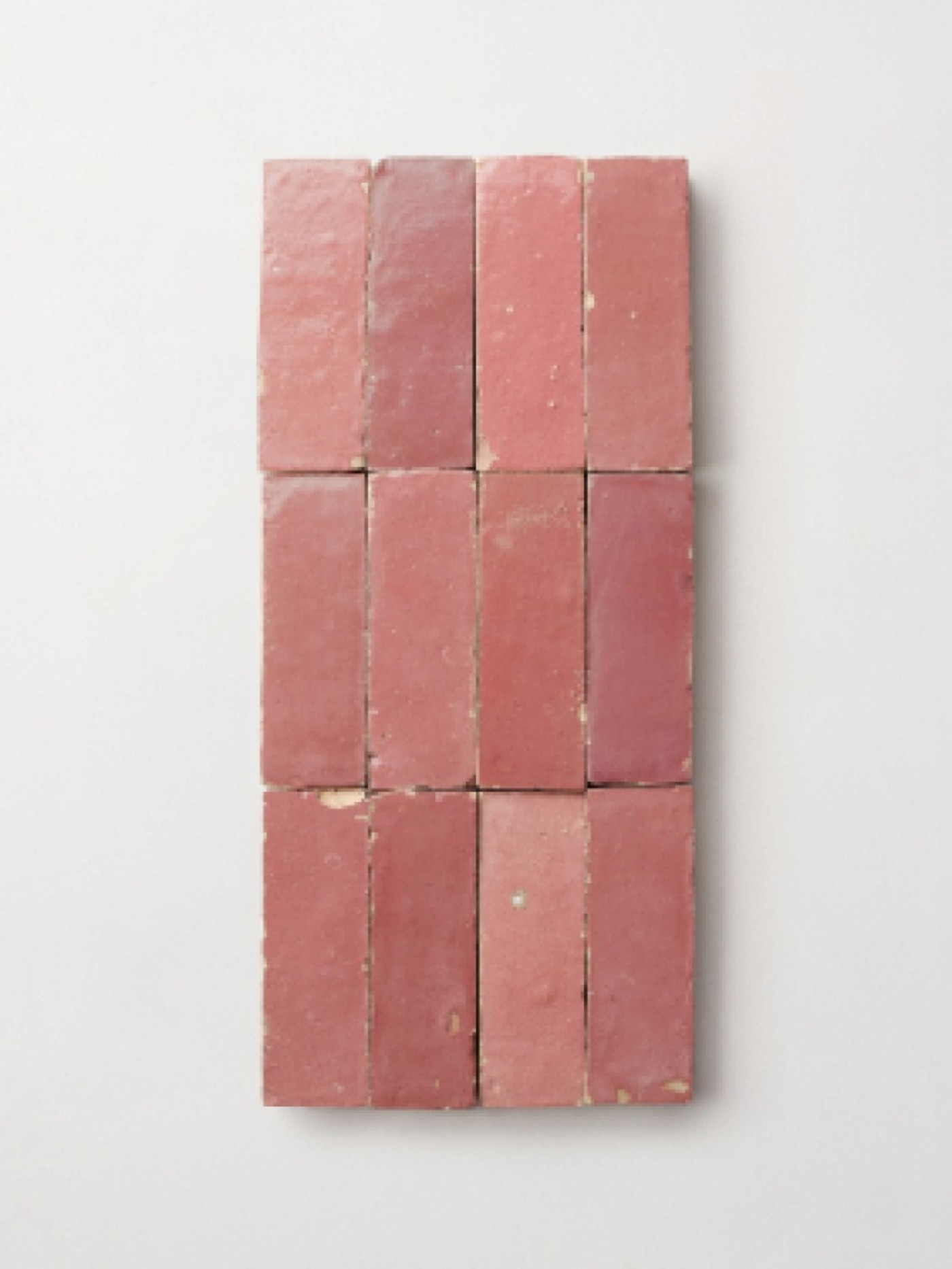 a group of pink tiles on a white surface.