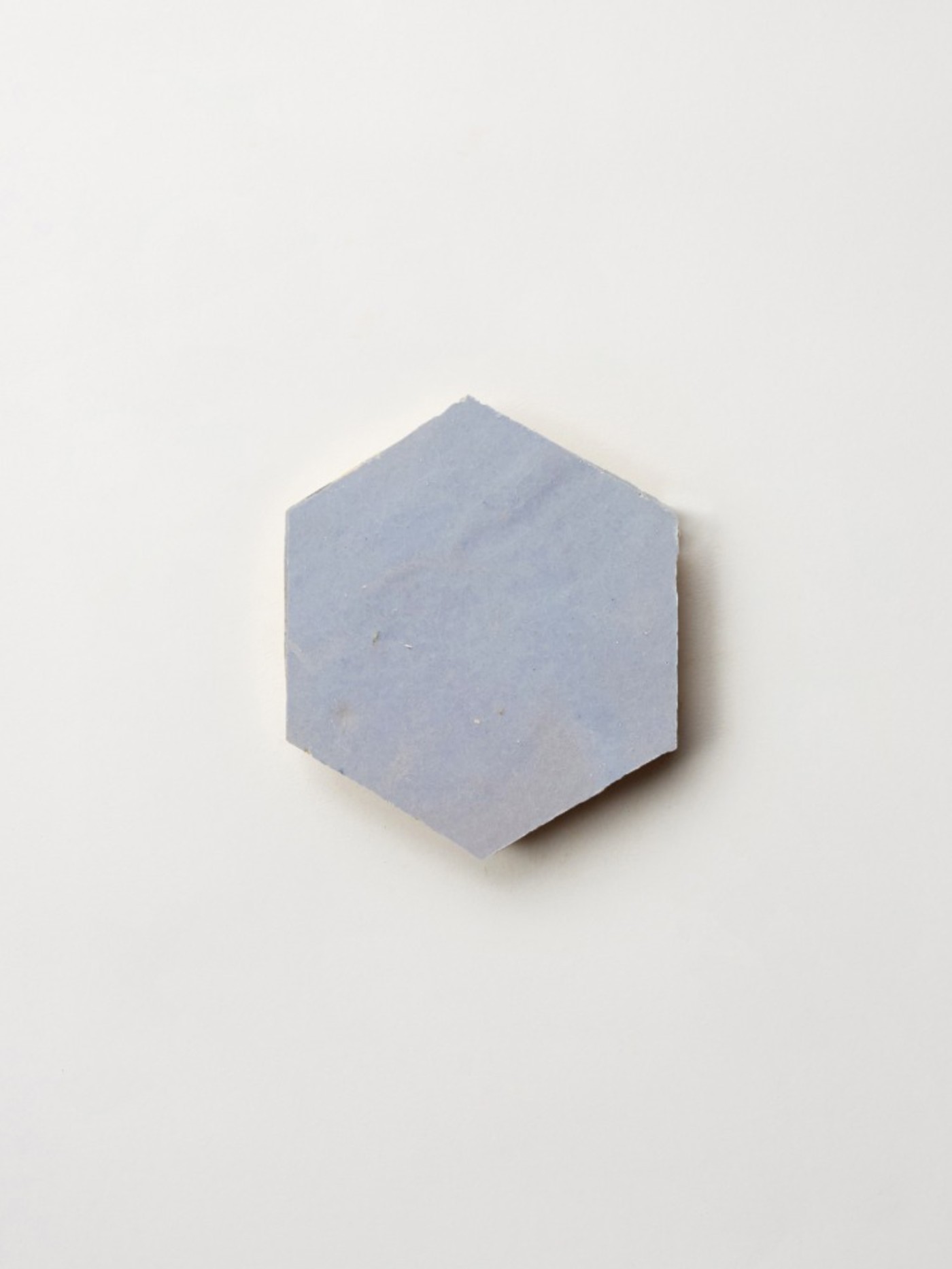 a blue hexagonal tile on a white surface.