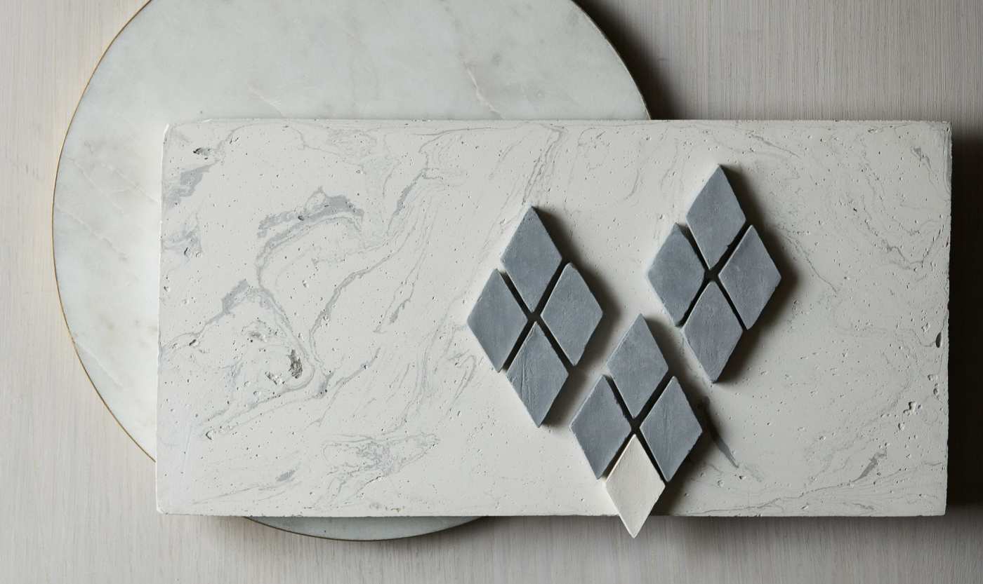 a piece of marble with a group of small grey diamond tiles on it.