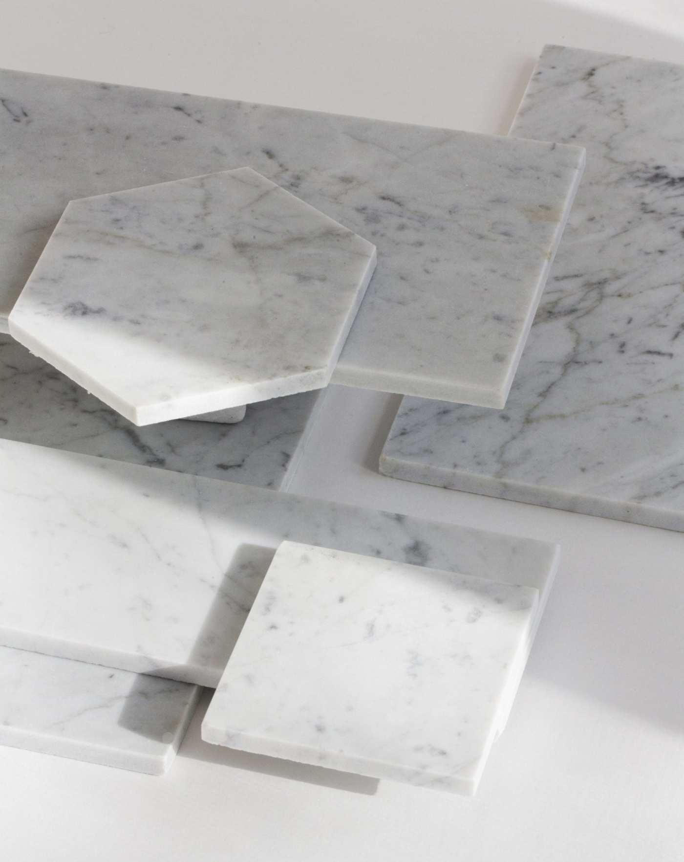 a group of white marble tiles on a white surface.