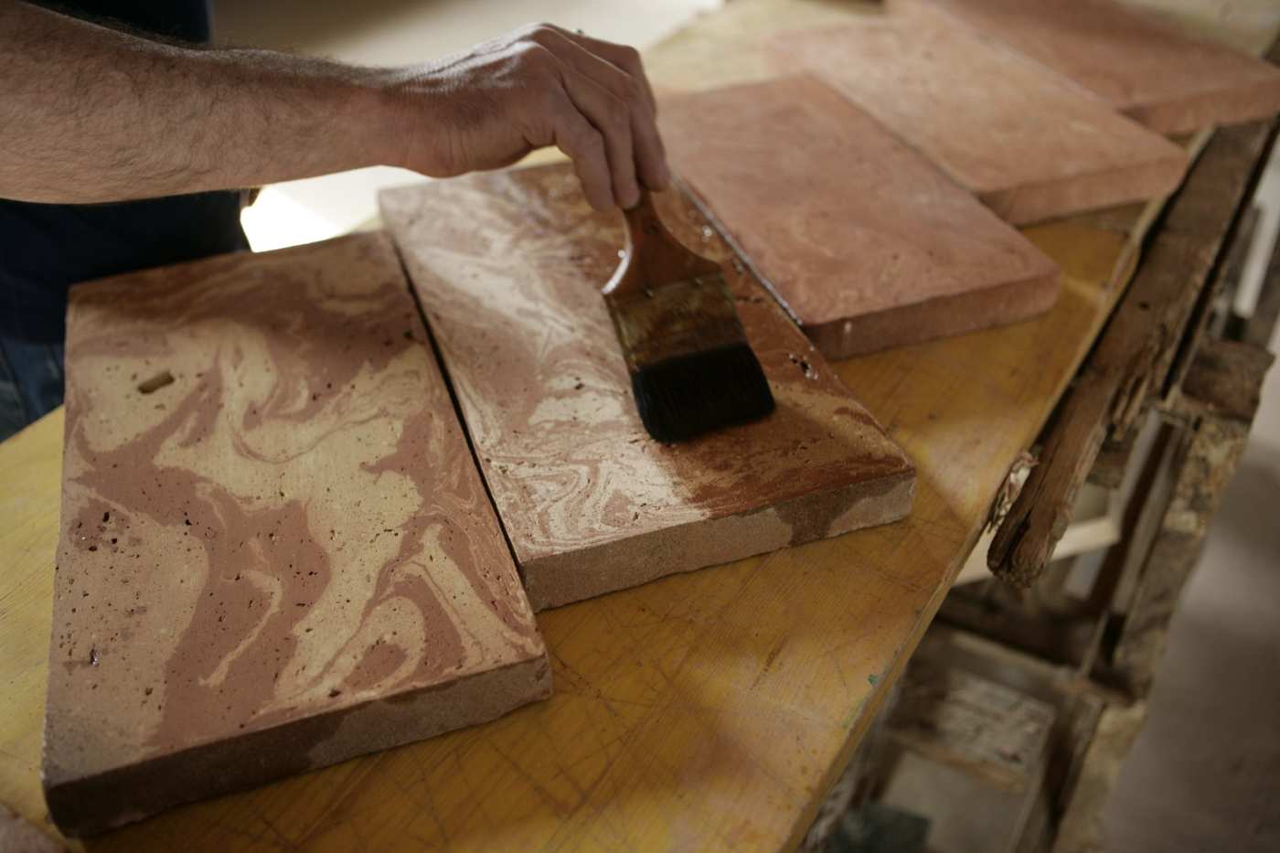 a man is using a brush to polish some tiles.