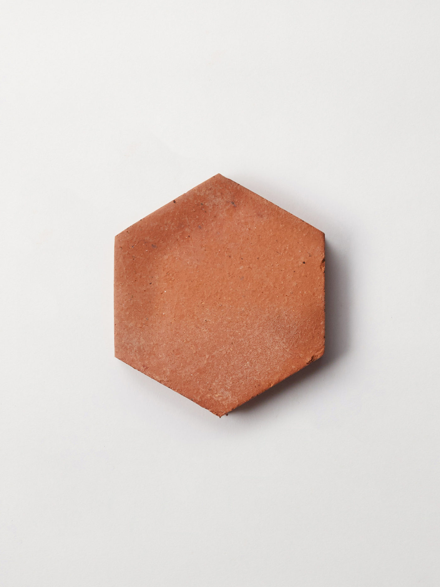 a red hexagonal tile on a white surface.