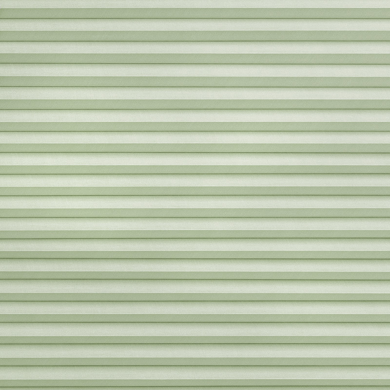 Light green pleated cellular shades spanning the frame, fully lowered and closed with horizontal ribbed texture, softly filtering diffuse daylight into a neutral, softly lit interior.