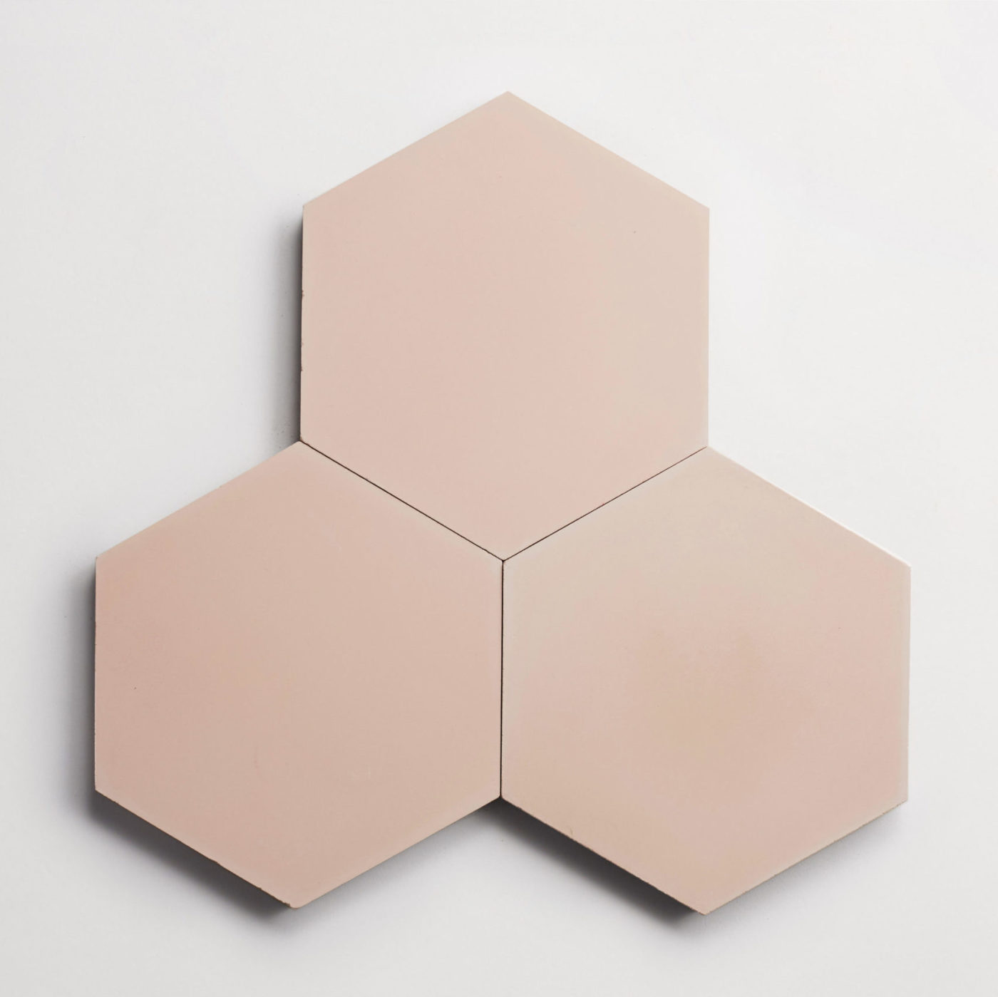 three pink hexagon tiles on a white surface.