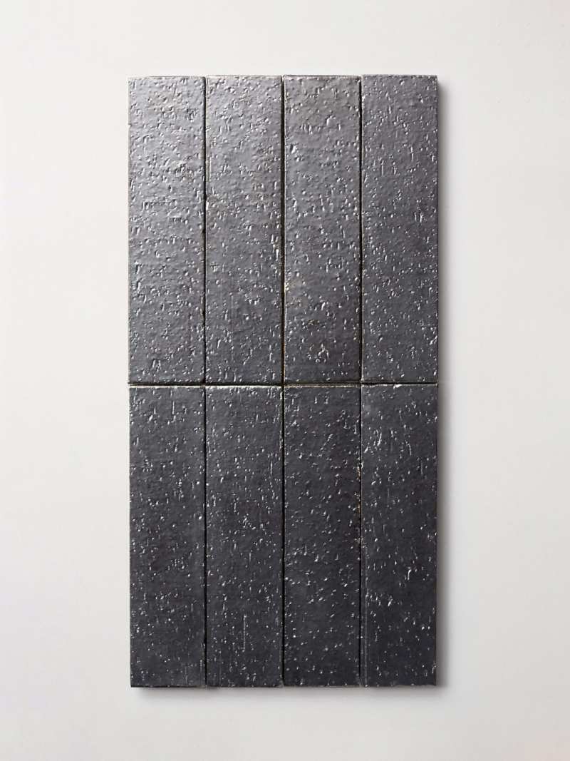 a black slate tile hanging on a wall.