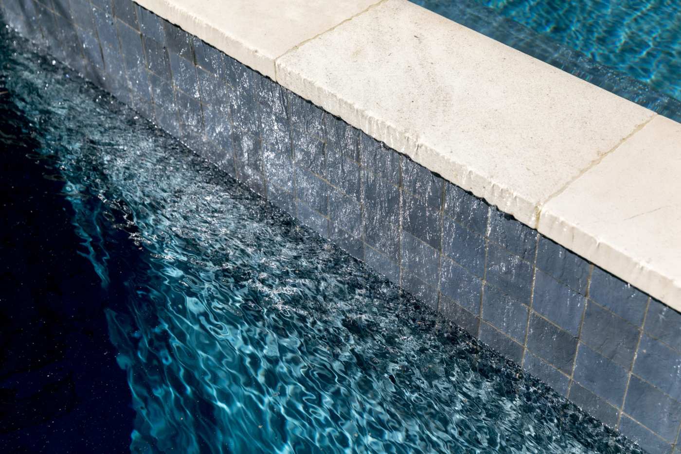 a swimming pool with grey tiles.