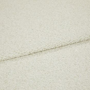 Cream bouclé fabric folded into overlapping layers, showing a horizontal seam; close-up view with soft, even lighting emphasizing the looped texture in a neutral studio setting.