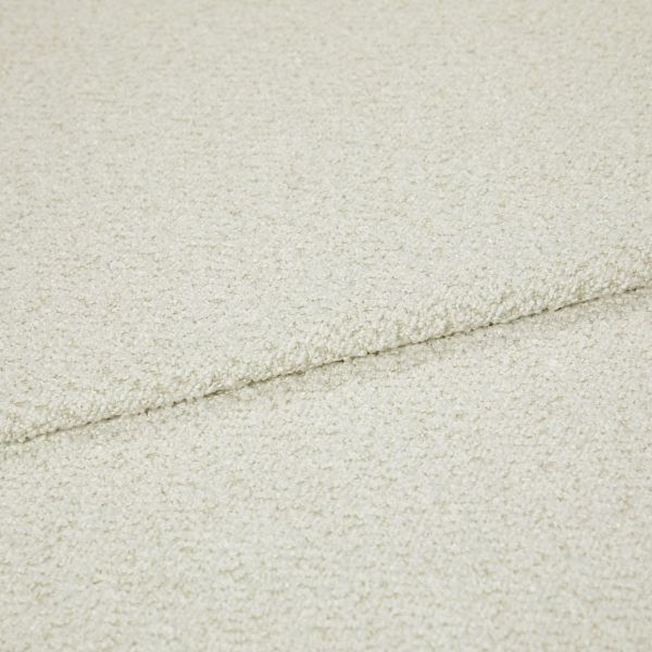 Cream bouclé fabric folded into overlapping layers, showing a horizontal seam; close-up view with soft, even lighting emphasizing the looped texture in a neutral studio setting.
