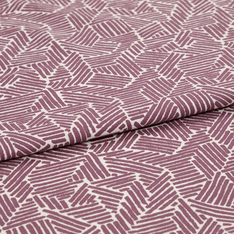 Folded printed cotton fabric with mauve geometric stripe blocks, repeating irregular parallelograms; folded edge runs diagonally, fabric lies flat under soft studio lighting for a close-up textile view.